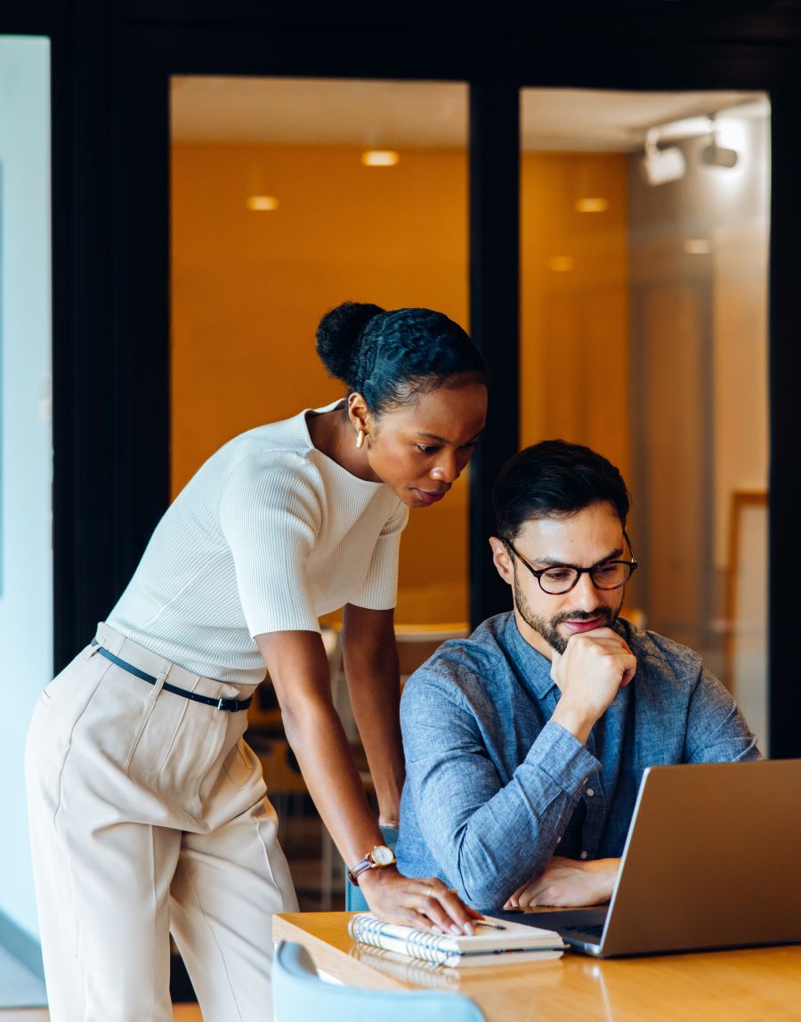 Make and female colleagues looking at the laptop